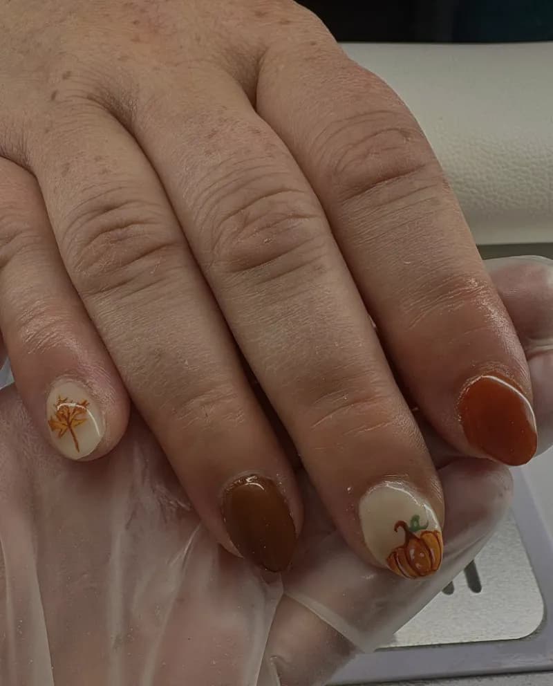 Autumn nails with a hand-painted pumpkin and leaves
