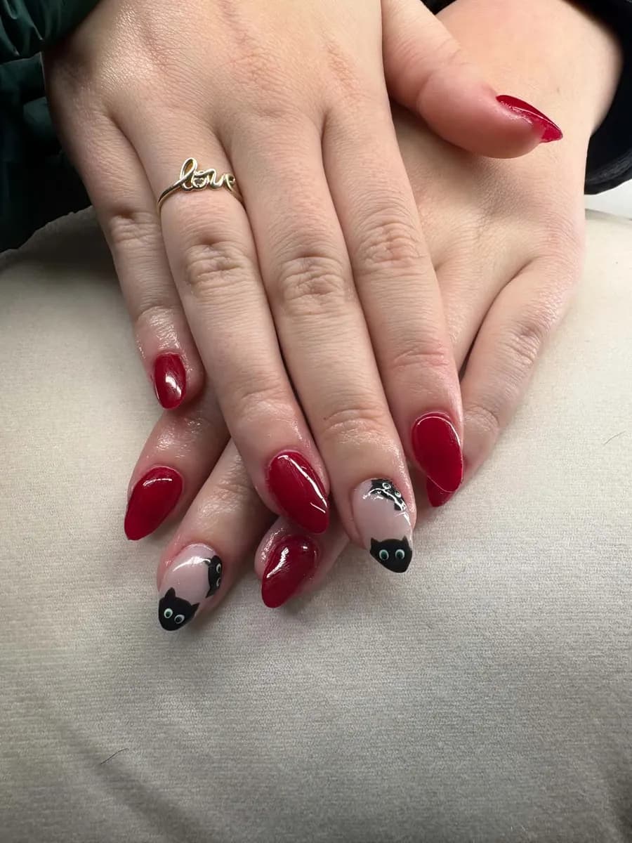 Glossy red almond nails with little black cat accent nails