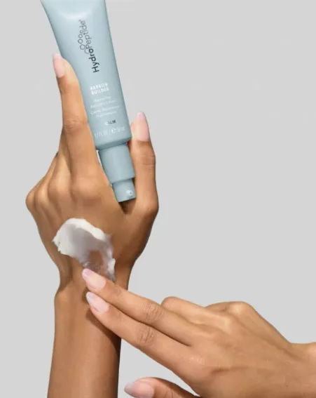 A light blue tube of HydroPeptide Barrier Builder, with cream on the wrist