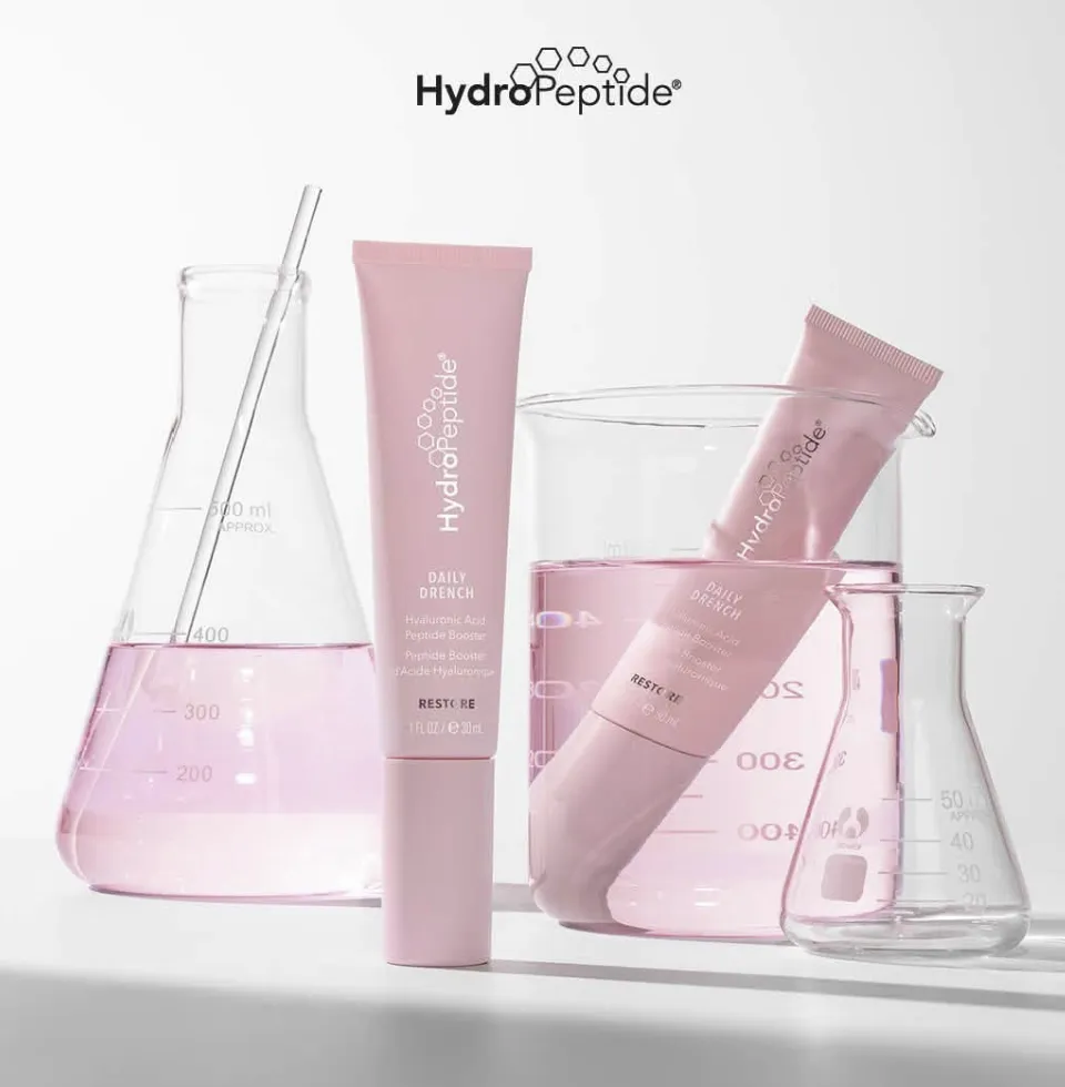 Pink HydroPeptide Daily Drench tubes with glass beakers